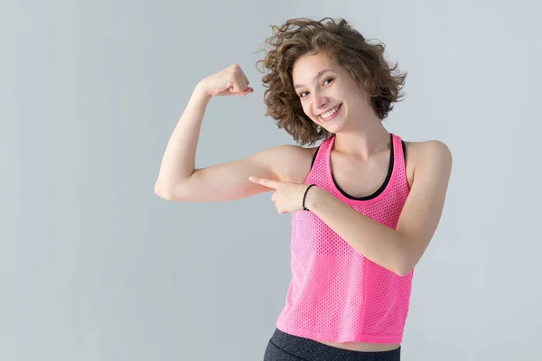 Curly Jonge Vrouw Stak Haar Hand Omhoog Wijzend Naar Spieren — Stockfoto