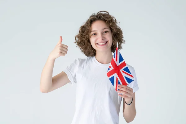 喜欢它 卷曲的年轻女子 高举玉旗 站在白色的背景上 学英语很酷 — 图库照片