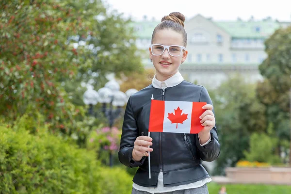 在城市公园的背景下 戴着悬挂加拿大国旗的眼镜的女学童 — 图库照片