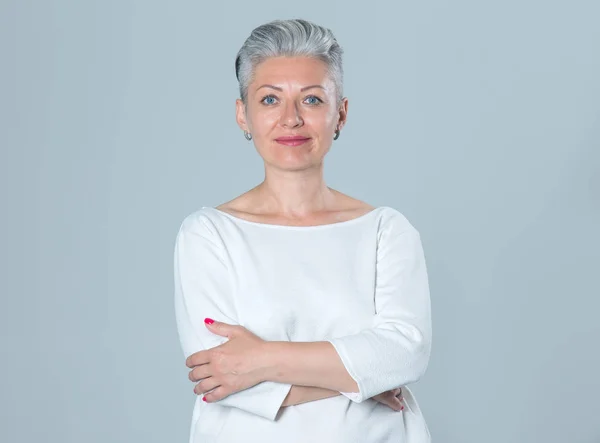 Kısa saçlı ve gri saçlı olgun bir kadının portresi..