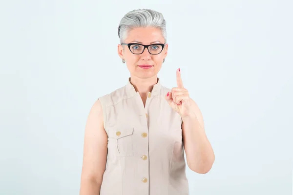 Μεσήλικη Γυναίκα Γυαλιά Δείχνει Ένα Δάχτυλο Πάνω Στέκεται Ένα Ελαφρύ — Φωτογραφία Αρχείου