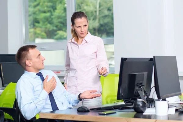Female manager checks the work of a subordinate man, she is unhappy, he is to blame. The boss is outraged by the work of the office employee.