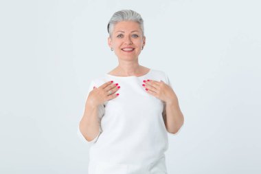 Beyaz elbiseli mutlu olgun bir kadının portresi açık bir arka planda duruyor..
