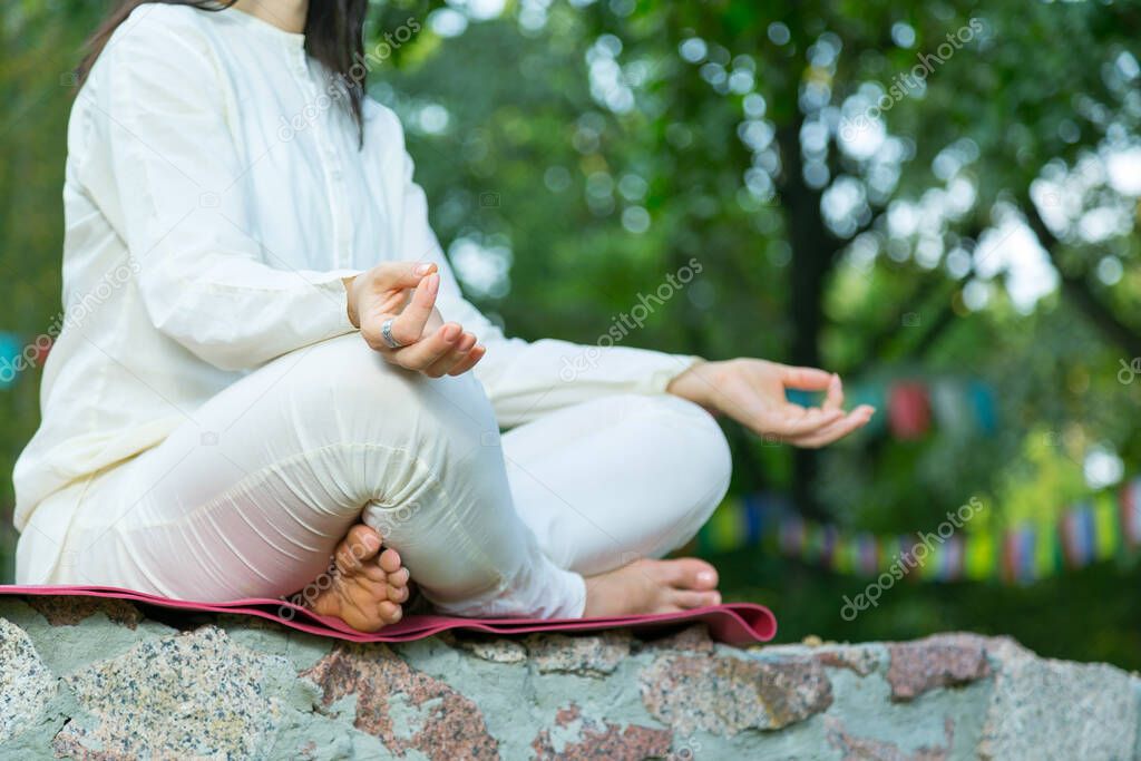 Close up of female hands. Woman is practicing yoga and meditation. Relax in nature. Woman during retreat classes.