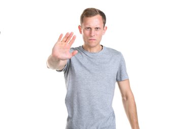 Dikkat! Dikkat! Genç bir adam elini önünde uzattı, durmak için işaret etti, beyaz bir arka planda izole bir şekilde..