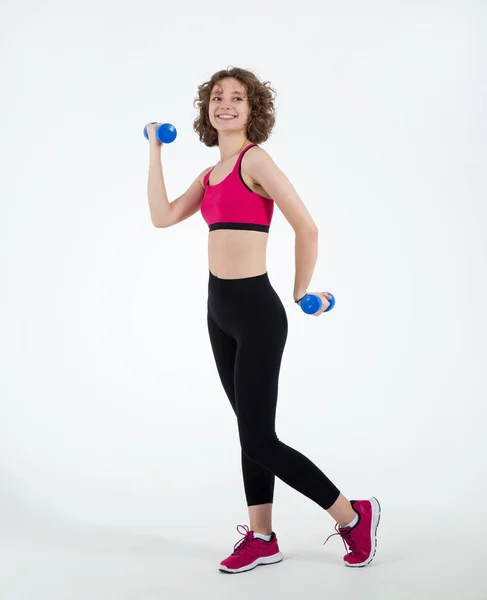 全身而退 年轻的女运动员 手里拿着哑铃 站在白色的背景上做健身锻炼 — 图库照片
