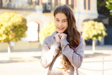 Şehrin arka planındaki kameraya gülümseyen mutlu kızın portresi..