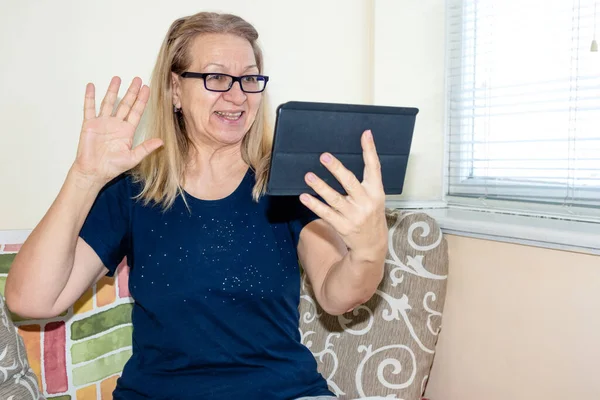 Hola Mujer Madura Hace Una Llamada Telefónica Usando Una Tableta Imágenes de stock libres de derechos