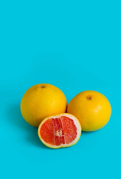 Pomelos Enteros Medio Sobre Fondo Azul Imagen Vertical —  Fotos de Stock