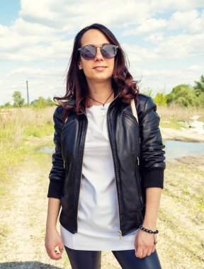 Deri ceketli ve güneş gözlüklü genç bir kadının portresi..