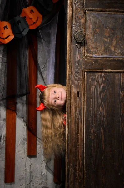 Блондинка Хэллоуин Дьявол Девушка Красными Рогами Глядя Старой Деревянной Двери — стоковое фото