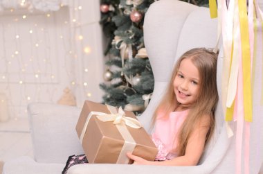 Hediye kutusu sandalye Noel iç oturan elinde güzel çocuk kızla
