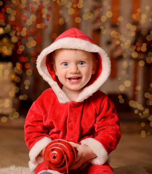 笑婴儿装扮成圣诞老人圣诞节背景散景新年灯 — 图库照片
