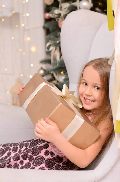 Menina Bonita Com Caixa Presente Mãos Sentadas Cadeira Interior Natal — Fotografia de Stock