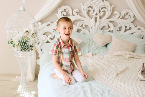 Lachender Junge Sitzt Hellem Zimmer Auf Bett — Stockfoto