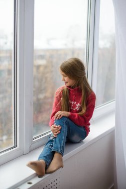 Kız pencere kenarında oturuyor, pencere camının yanında, sokakta yürümek istiyor, ama dünyada koronavirüs salgını var, ve karantinada kalıyor.