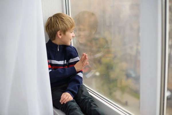 Junge Sitzt Auf Fensterbank Neben Fensterscheibe Auf Straße Gehen Aber — Stockfoto