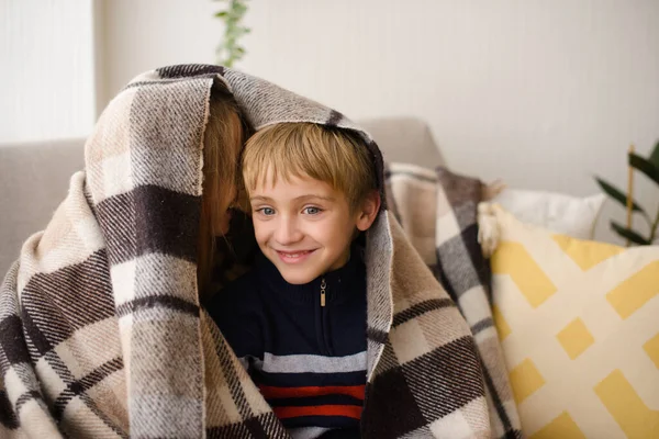 男の子と女の子 姉と弟はソファの上で毛布の下に座って 夢を見て 抱き合って 家の明るい部屋で — ストック写真