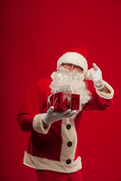 Foto do tipo Papai Noel dando xmas presente e olhando para cam — Fotografia de Stock