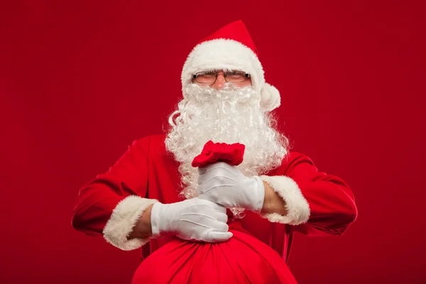 Jultomten med stor säck på axel glasögon röd bakgrund — Stockfoto