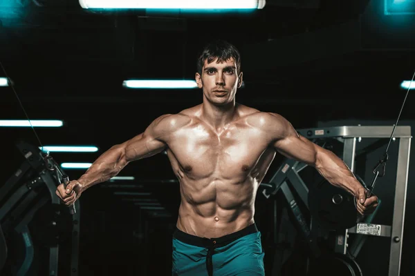 Handsome bodybuilder works out pushing up excercise in gym — Stock Photo, Image