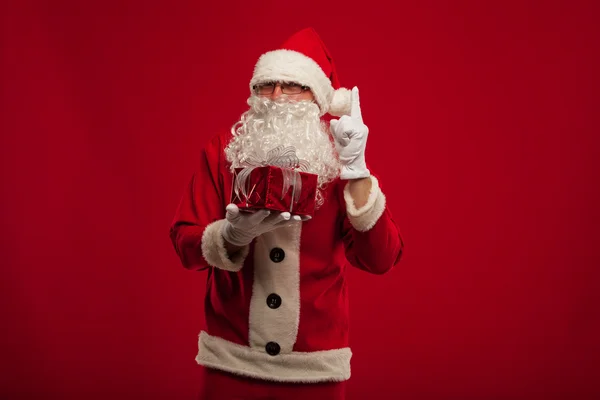 Foto von Art Weihnachtsmann, der Weihnachtsgeschenk macht und Nocken anschaut — Stockfoto