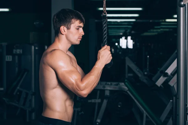 Hombre musculoso haciendo ejercicio en el gimnasio haciendo ejercicios en tríceps, fuertes abdominales masculinos desnudos del torso —  Fotos de Stock