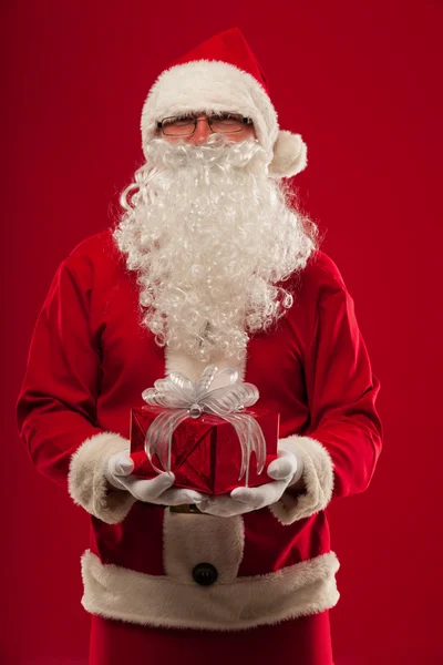 Photo of kind Santa Claus giving xmas present and looking at cam — Stock Photo, Image