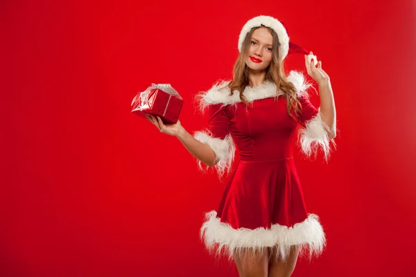 Natal, x-mas, inverno, conceito de felicidade - mulher sorridente em chapéu de Papai Noel ajudante com caixa de presente, sobre fundo vermelho — Fotografia de Stock