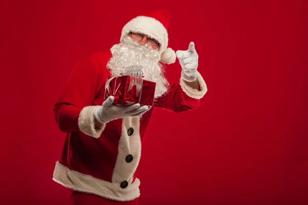 Photo of kind Santa Claus giving xmas present and looking at cam — Stock Photo, Image