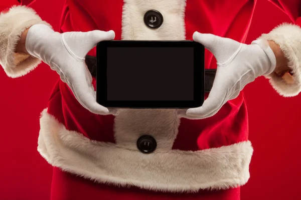 サンタ クロースがタブレットを保持しています。赤い背景、手 — ストック写真