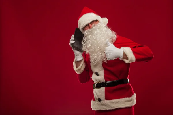 Fröhlicher Weihnachtsmann telefoniert mit Handy und zeigt okay Geste. — Stockfoto