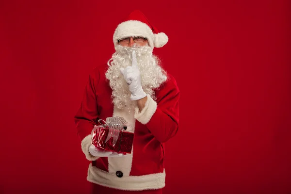 Photo of kind Santa Claus giving xmas present and looking at cam — Stock Photo, Image