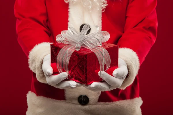 Foto de tipo Santa Claus dando regalo de Navidad y mirando a la cam — Foto de Stock