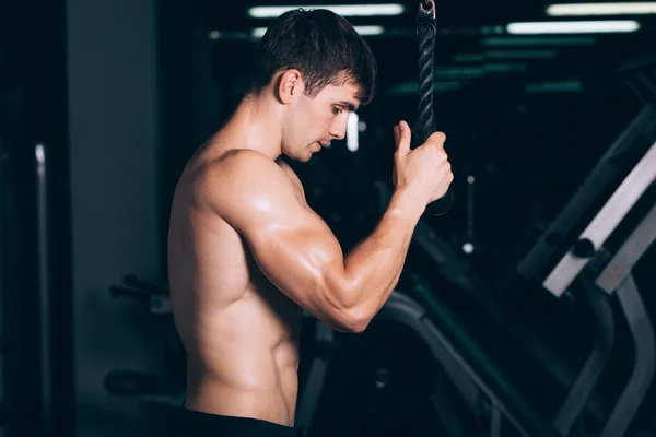 Svalnatý muž pracuje v tělocvičně CVÍČENÍ na triceps, silný muž nahý trup abs — Stock fotografie