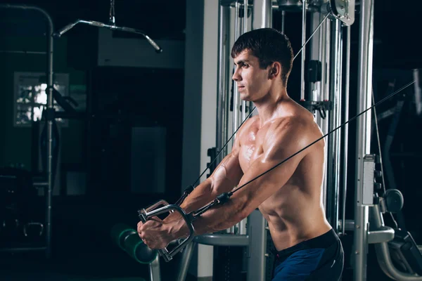 Spor salonunda egzersiz kadar iterek yakışıklı vücut geliştirmeci çalışır — Stok fotoğraf