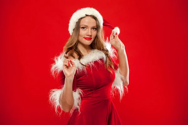Karácsonyi közel fel santa claus ruhát visel, mint piros háttér gyönyörű szexi lány portréja — Stock Fotó