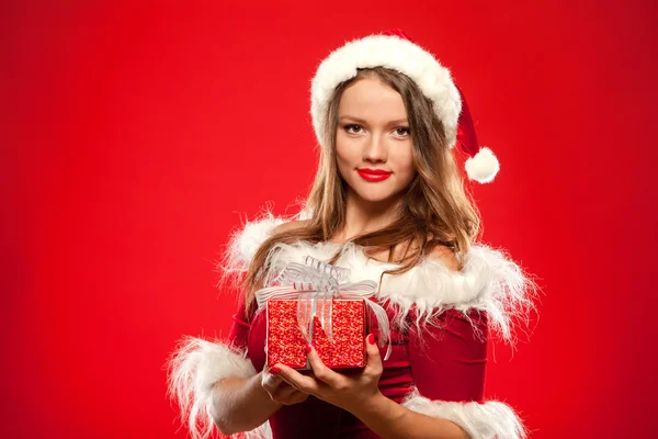 Natal, x-mas, inverno, conceito de felicidade - mulher sorridente em chapéu de Papai Noel ajudante com caixa de presente, sobre fundo vermelho — Fotografia de Stock