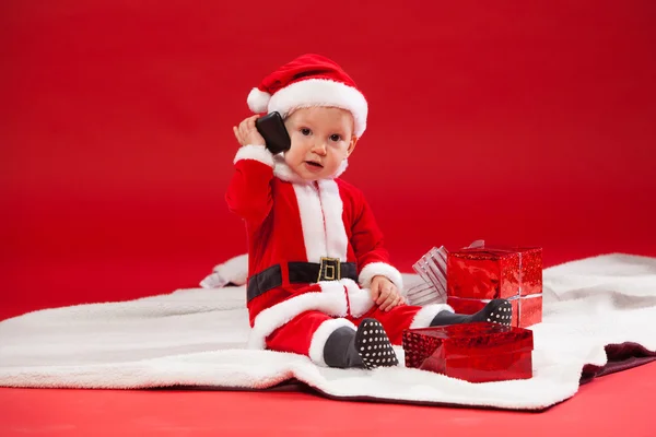 Красивий маленький дитина святкує Різдво. Нові років свята. з подарунком і телефон — стокове фото