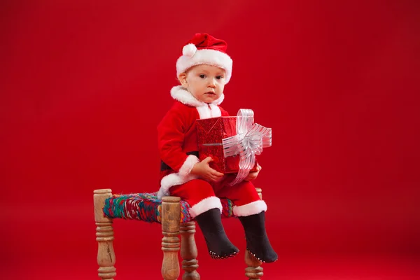 Beautiful little baby celebrates Christmas. New Years holidays. with gift — Stockfoto