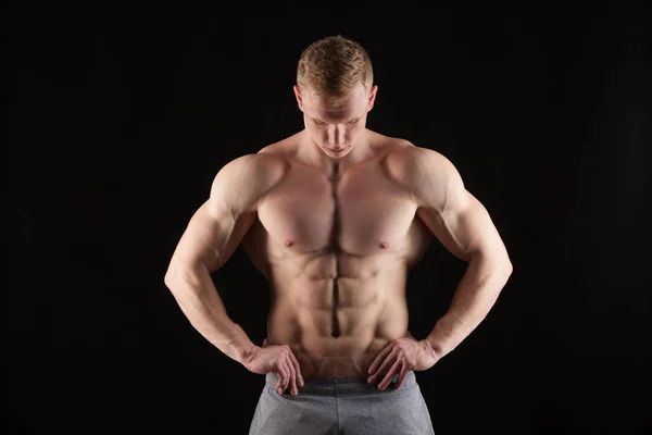 Knappe man van de atletische fitness-model weergegeven: zes pack abs. geïsoleerd op zwarte achtergrond met copyspace — Stockfoto