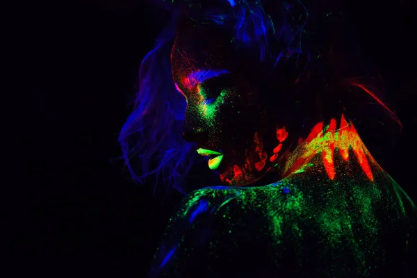 Schöne außerirdische Model-Frau mit blauem Kopf und grünen Lippen in Neonlicht. es ist Porträt des schönen Modells mit fluoreszierendem Make-up, Kunstdesign der weiblichen posiert in UV mit buntem Make-up — Stockfoto