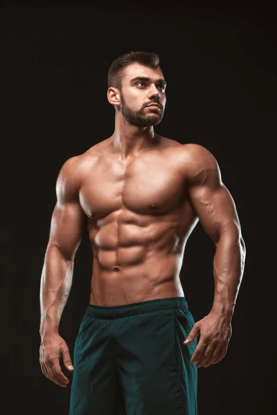 Homem Atlético Forte Modelo Fitness mostrando suas costas perfeitas isoladas em fundo preto com copyspace — Fotografia de Stock