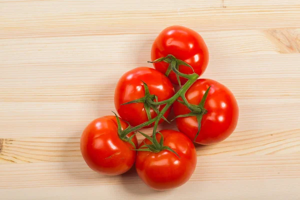 Tomates rojos frescos en la mesa de madera, aislados — Foto de Stock