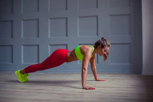 Mulher fitness bonita está fazendo flexões no ginásio , — Fotografia de Stock