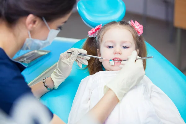 Close-up de menina bonita abrindo a boca durante a inspeção da cavidade oral no dentista — Fotografia de Stock