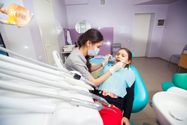 Hezká holčička otevírání ústa během léčení zubů zubním lékařem — Stock fotografie