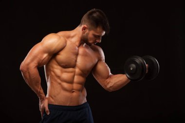 Yakışıklı güç güvenle ileriye dumbbell atletik adamla. Altı paket, mükemmel abs, omuzlar, pazı, triceps ve siyah arka plan ile boşaltmak izole göğüs ile güçlü vücut geliştirmeci