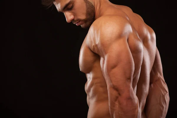 Forte atletico uomo - Modello di fitness che mostra la sua schiena perfetta isolato su sfondo nero con copyspace — Foto Stock