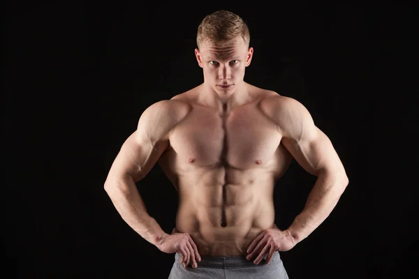 Knappe man van de atletische fitness-model weergegeven: zes pack abs. geïsoleerd op zwarte achtergrond met copyspace — Stockfoto